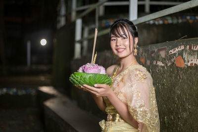 Portrait of young woman holding christmas tree