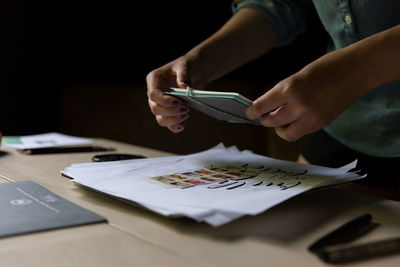 Midsection of woman holding craft product at table