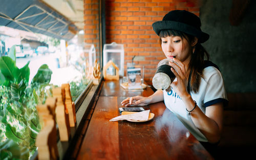 Young woman using laptop in restaurant