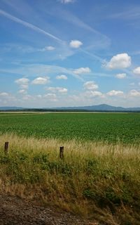 Scenic view of field against cloudy sky