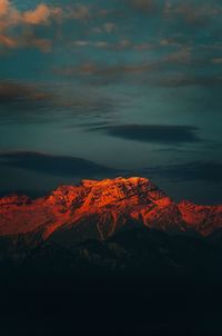 Scenic view of snowcapped mountains against sky at sunset