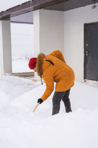 Rear view of man working on snow