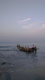 Men in boat on sea against sky