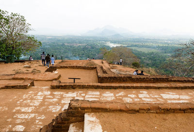 People on mountain against sky