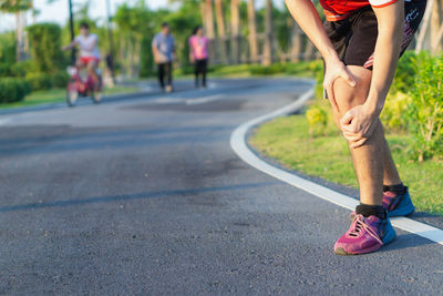Low section of woman walking on road