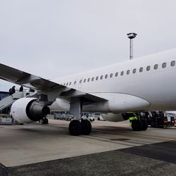 Airplane on airport runway against sky