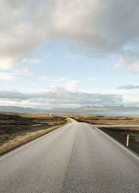 Surface level of empty road against cloudy sky