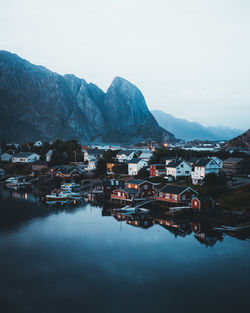 Houses by lake against sky