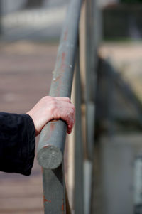 Close-up of hand holding metal railing