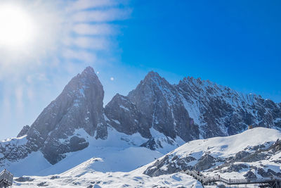 Scenic view of snowcapped mountains against blue sky