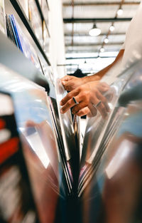 Cropped hand on metal in store with reflection