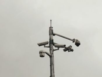 Low angle view of road side surveillance against grey sky