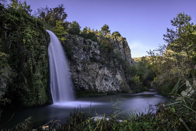 View of waterfall in lake