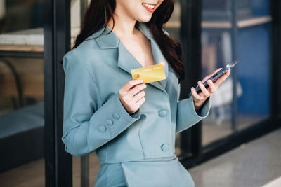 Midsection of woman using mobile phone