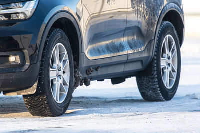 Car with studded tyres driving on a snowy road