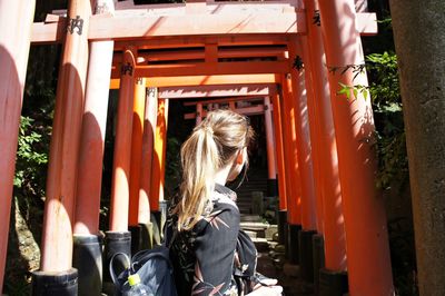 Woman standing by torii gates