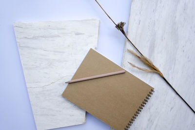 Notebooks, pencils and pencils are placed with a white background with white stones , top view 