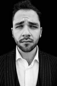 Close-up portrait of young man against black background