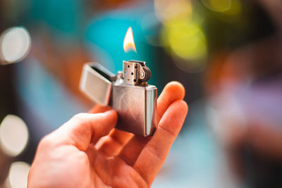 Close-up of hand holding burning lighter