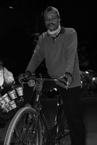 Portrait of man riding bicycle at night