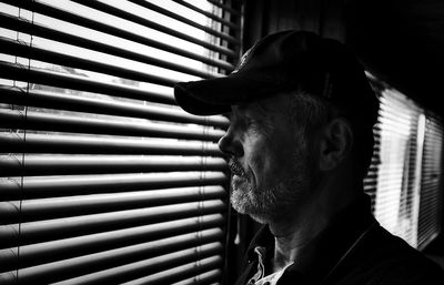 Close-up of man looking through window