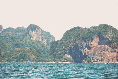 Scenic view of sea and mountains against clear sky