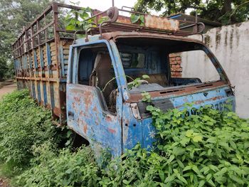 Abandoned rusty metal amidst plants