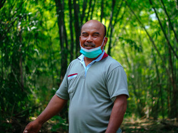 Portrait of man standing in forest