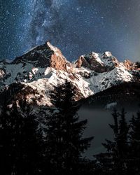 Scenic view of snowcapped mountains against sky at night