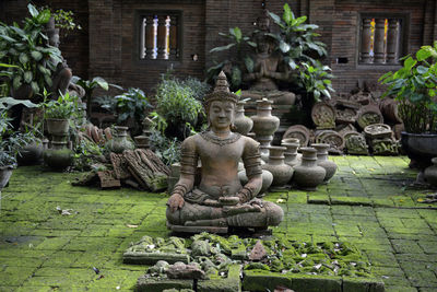 Weathered sculpture and urns outside building