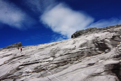 Low angle view of mountain against cloudy sky