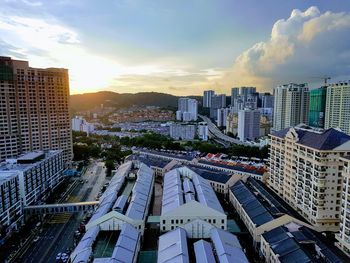 Aerial view of city against cloudy sky