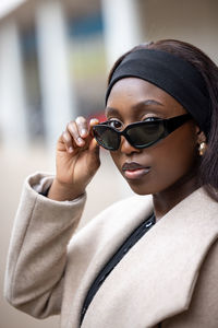 Portrait of young woman wearing sunglasses standing outdoors