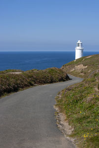 Lighthouse by sea against sky