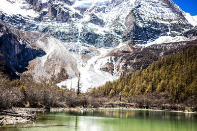 Scenic view of lake by mountain against sky