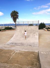 Rear view boy running on sports ramp