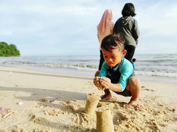 June 2020, asian boy playing sand beach alone at pantai teluk bayu, pulau pinang, malaysia