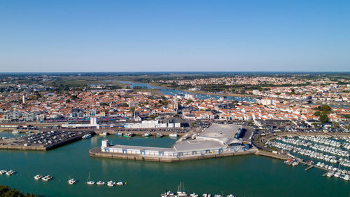 High angle view of buildings by sea against clear sky