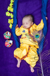 High angle view of cute baby girl sitting on bed