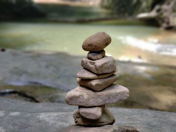 Close-up of stone stack on rock in lake