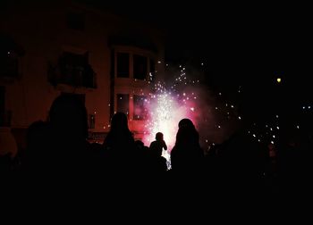 Silhouette people at concert against sky at night