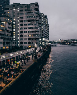 Aerial view of city by sea against sky