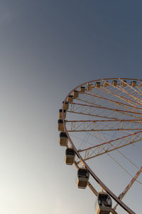 Low angle view of ferris wheel against clear sky