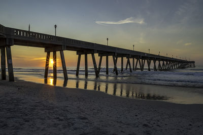 Pier over sea against sky during sunset