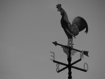 Low angle view of weather vane against clear sky