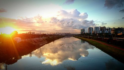 Sun shining through clouds over river