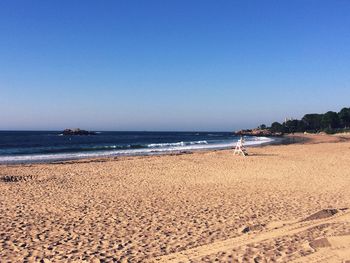 Scenic view of beach against clear blue sky