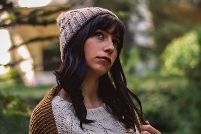 Close-up of thoughtful young woman standing outdoors