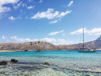 Sailboats moored on sea against sky