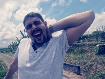 Portrait of smiling standing outdoors against sky